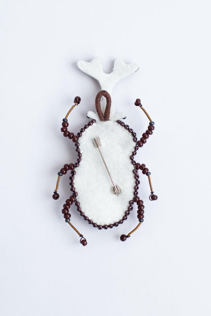 a brooch with beads and a deer head