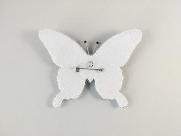 a white clock with a white butterfly on it
