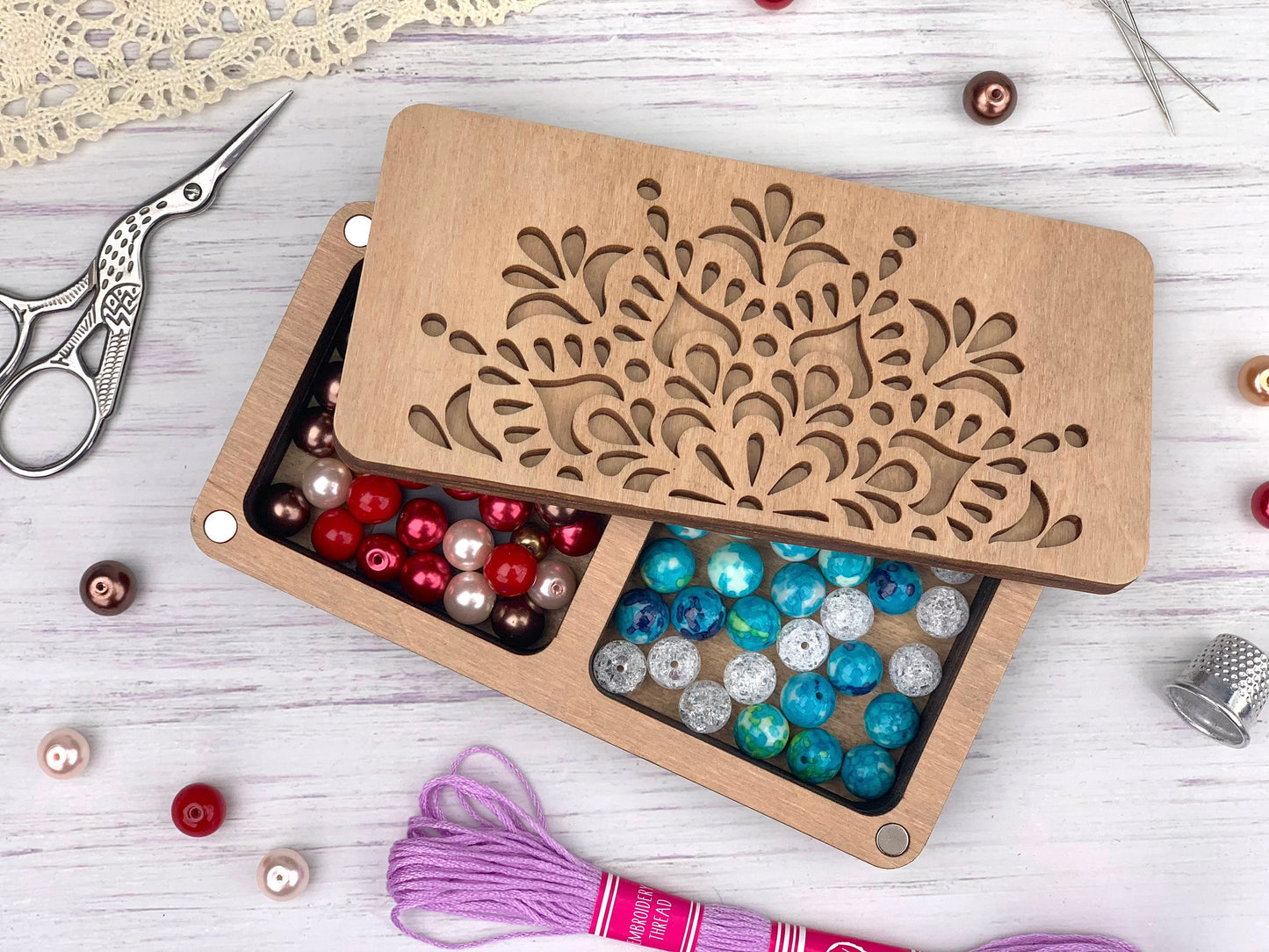 a pair of scissors and some beads in a box