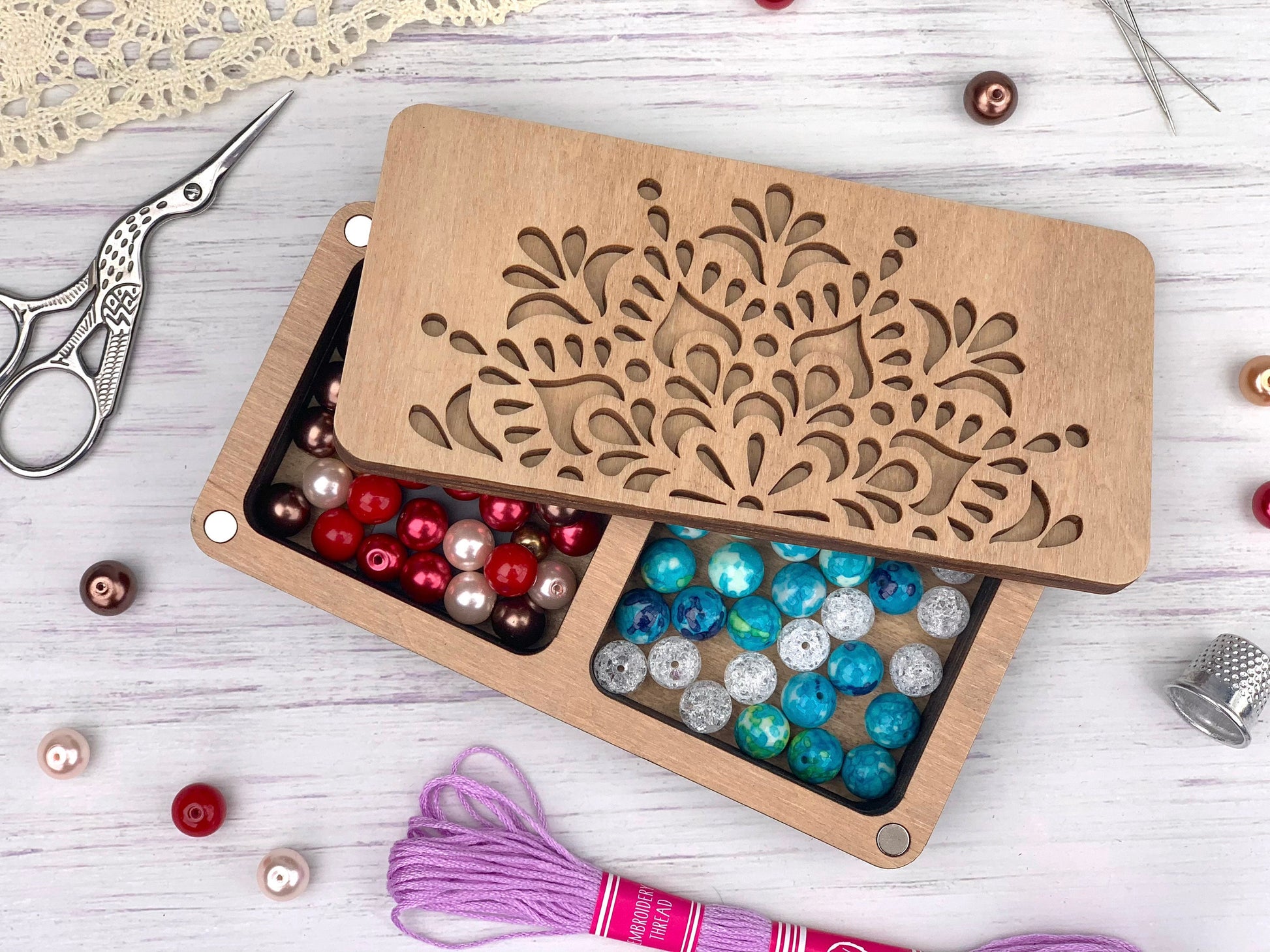 a pair of scissors and some beads in a box