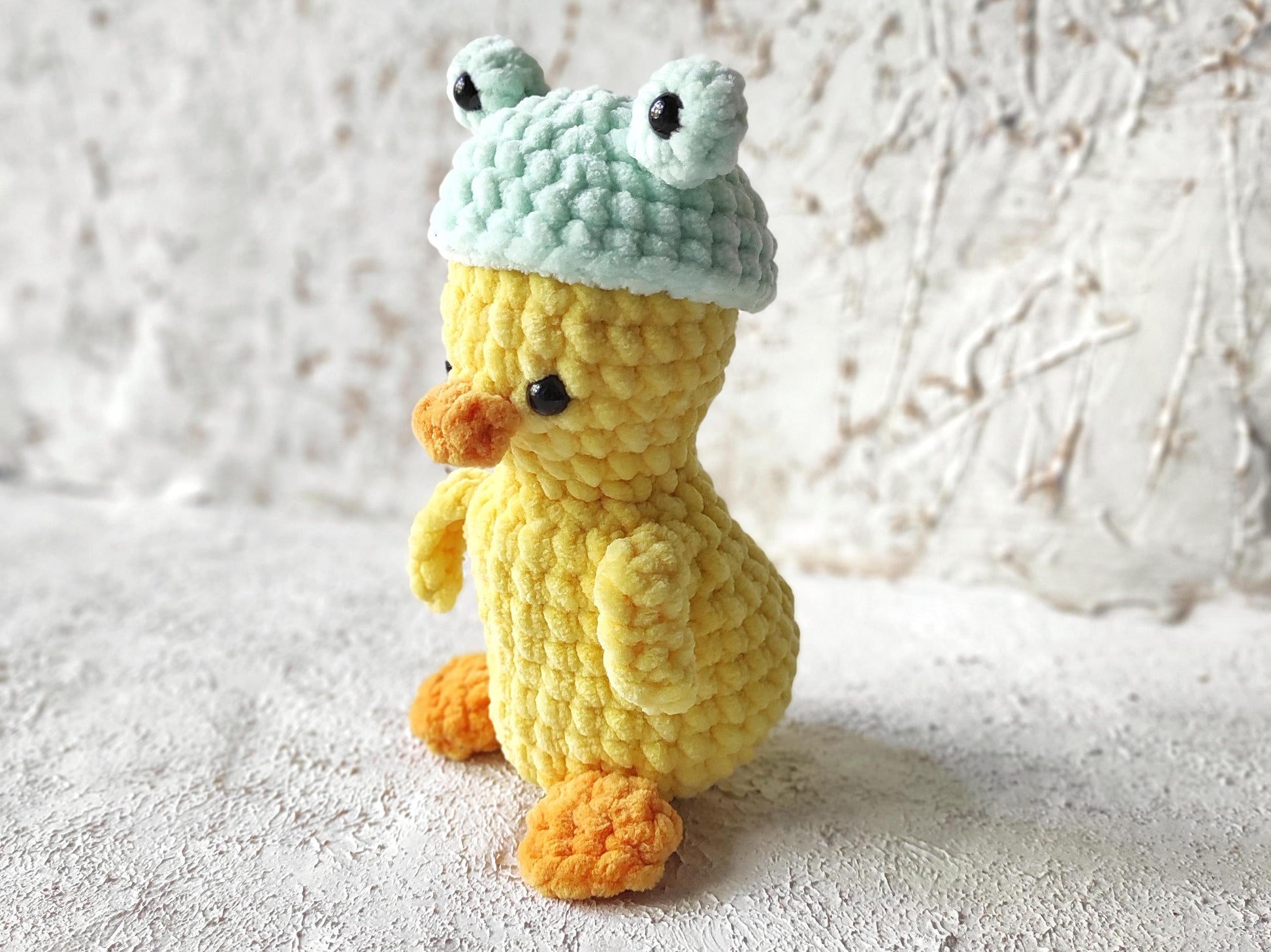 a crocheted toy duck wearing a knitted hat