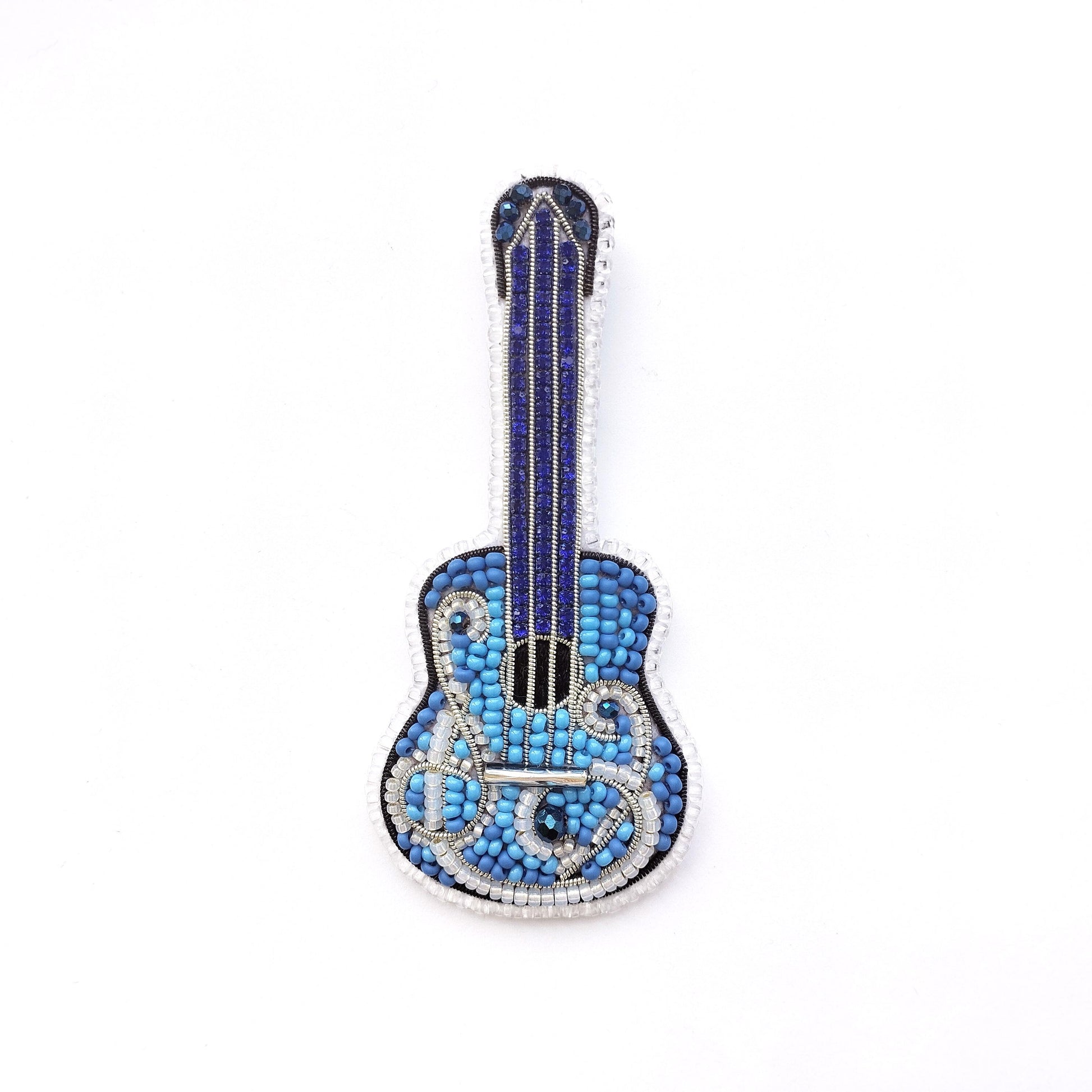 A blue and silver guitar-shaped brooch made of small blue beads and silver wire.