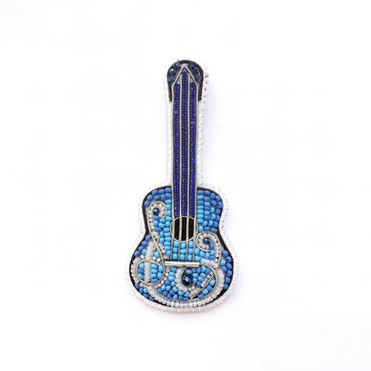A blue and silver guitar-shaped brooch made of small blue beads and silver wire.