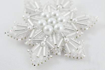 a snowflake made of pearls and crystal beads