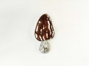 a brown and white beaded object on a white surface
