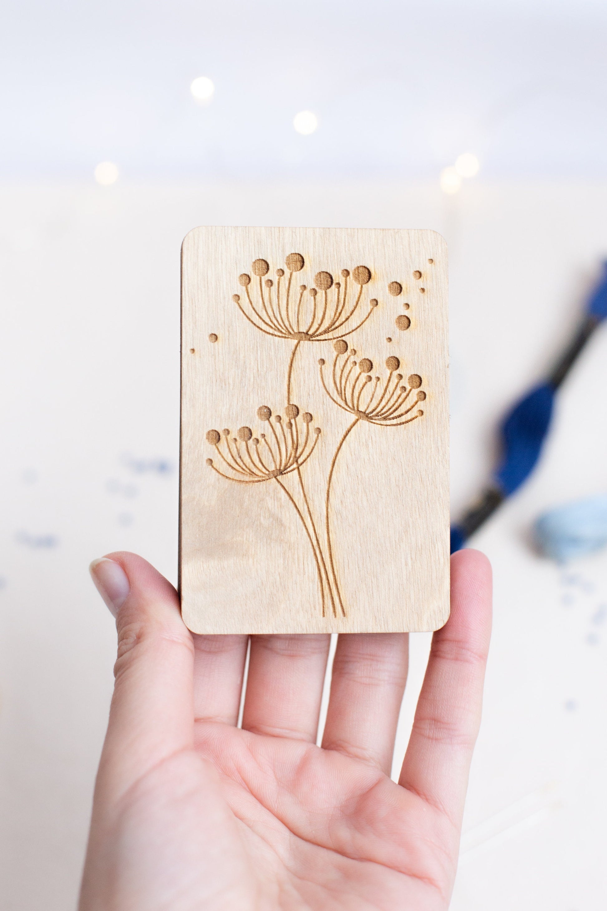 a hand holding a wooden stamp with flowers on it