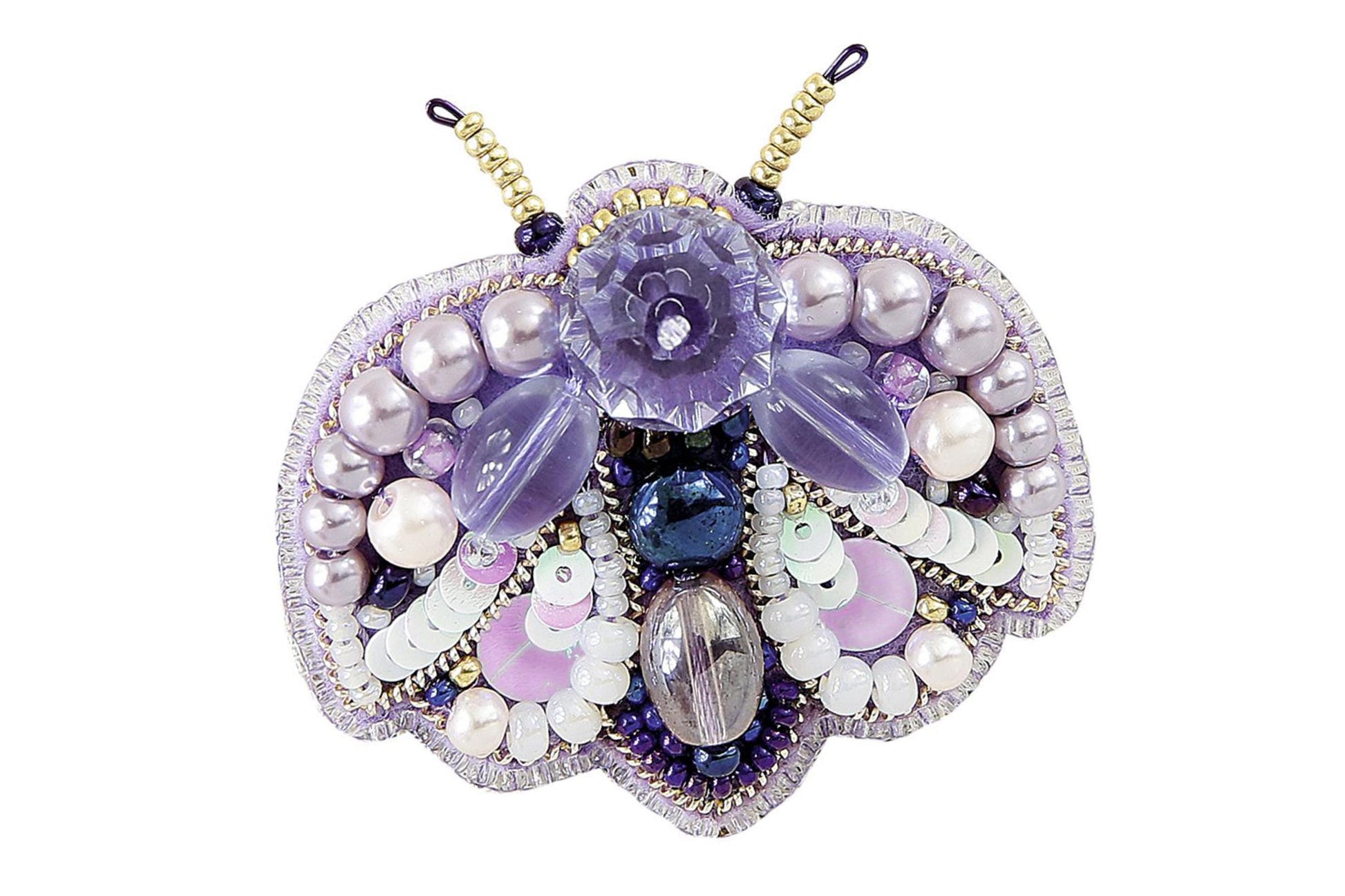 a purple brooch with pearls and beads