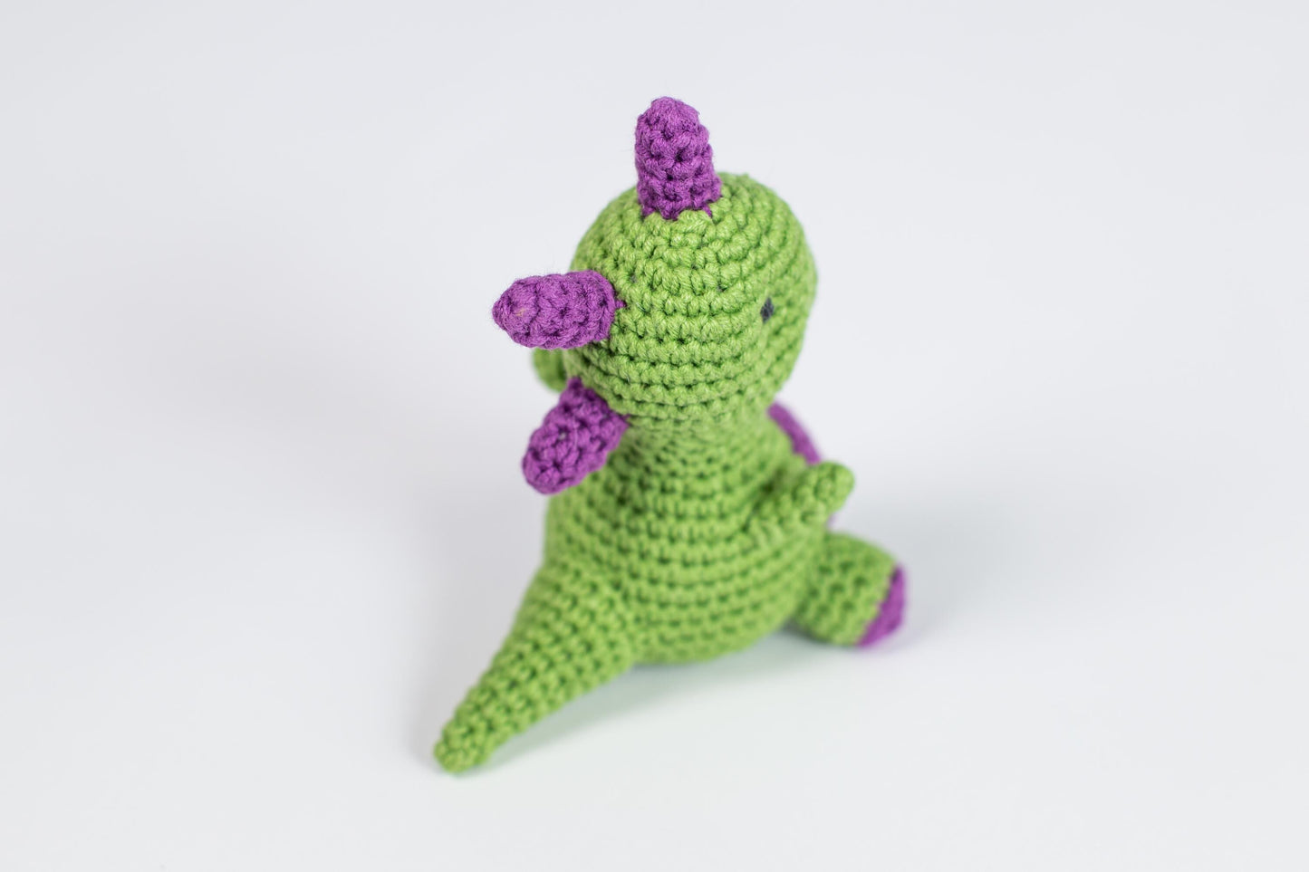 a crocheted toy is sitting on a white surface