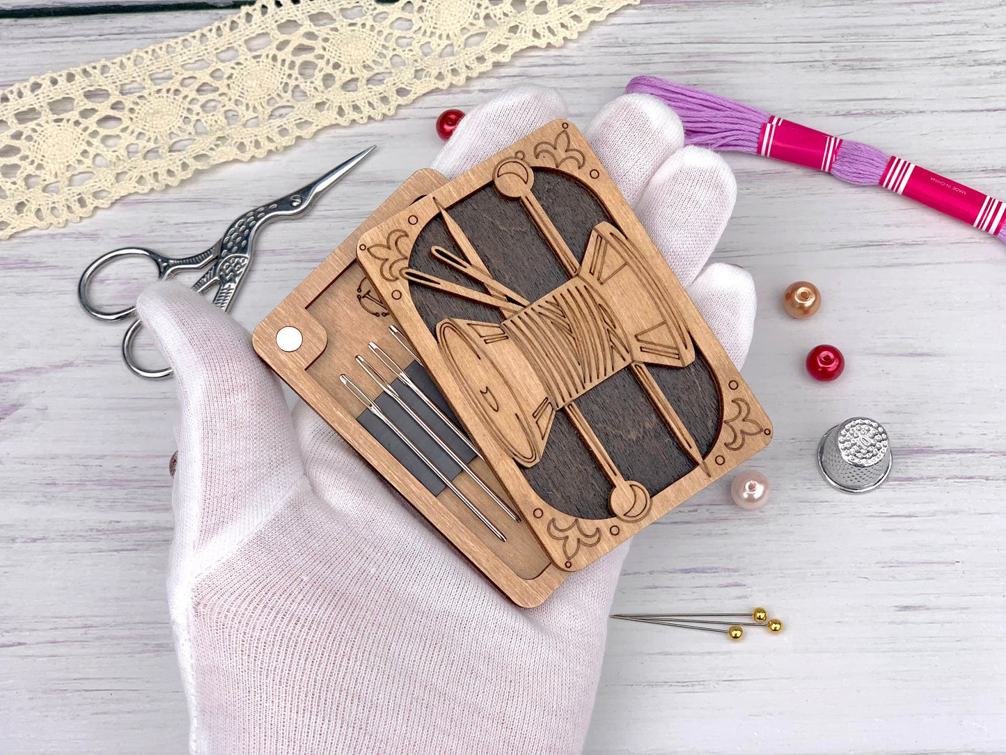 a hand holding a wooden clock on top of a table