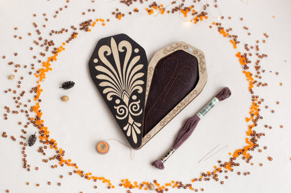 a heart shaped box with a tassel and thread