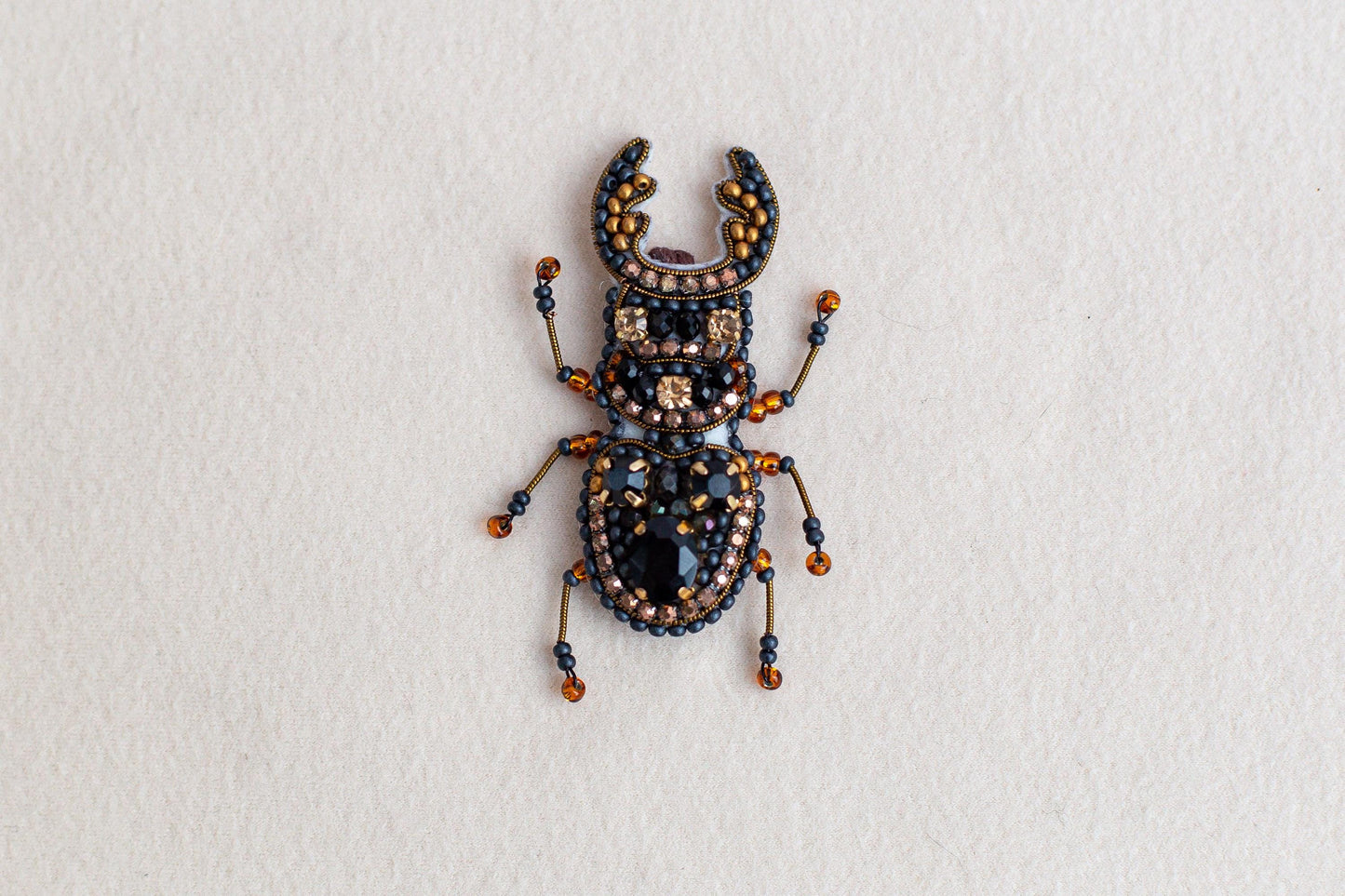 a bug made of beads and beads on a white surface