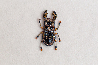 a bug made of beads and beads on a white surface