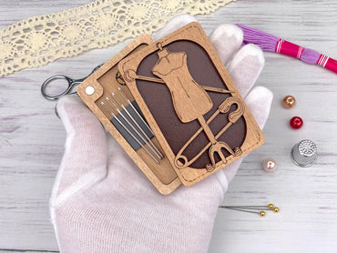 a hand holding a wooden cutout of a dressmaker