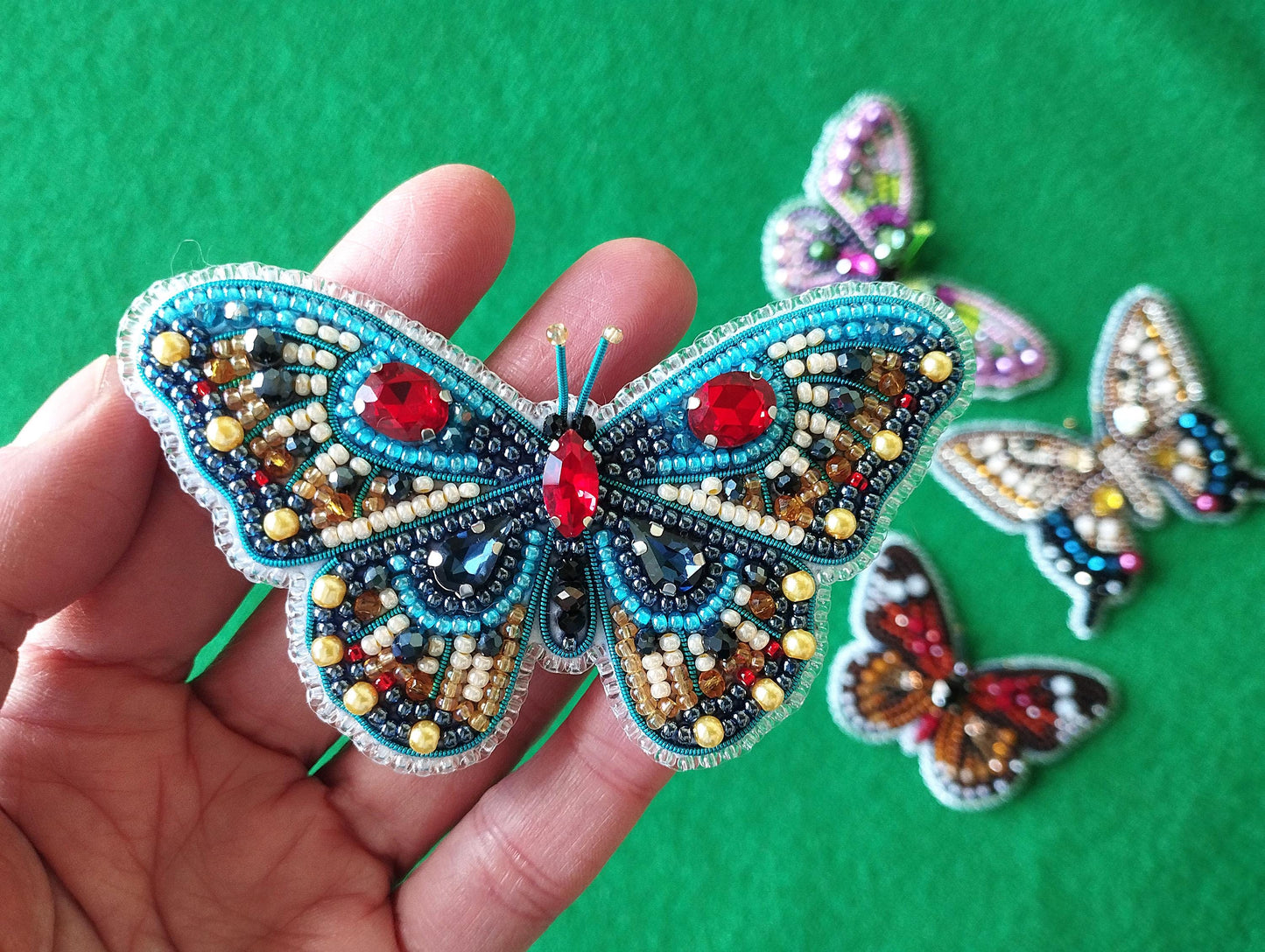 a hand is holding a small butterfly brooch