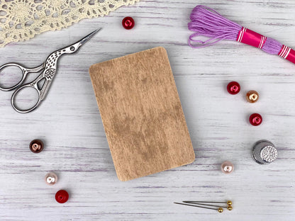 a wooden cutting board sitting on top of a table next to a pair of scissors