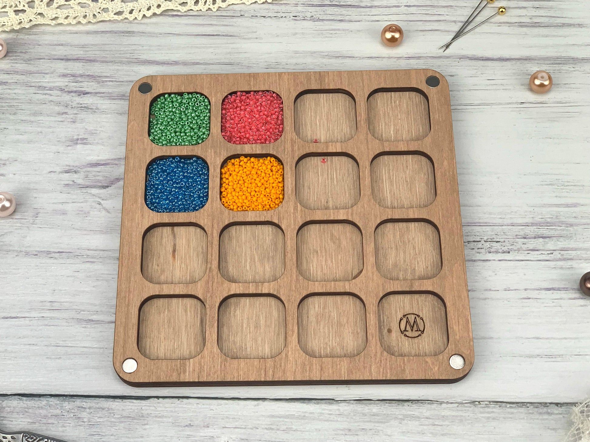 a wooden tray with beads and beads in it