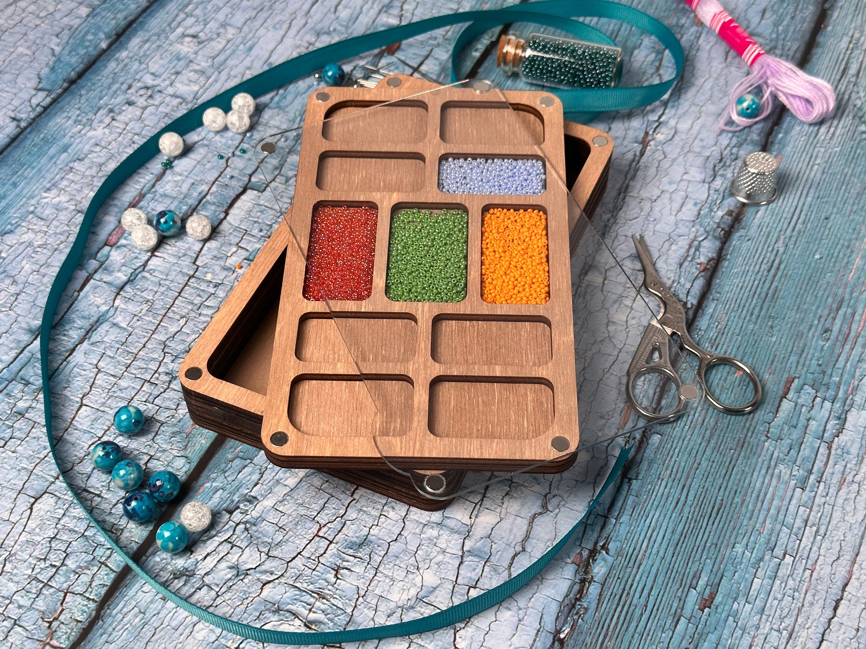 a wooden box filled with lots of different colored beads