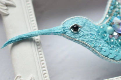 a blue bird with pearls and pearls on it&#39;s head