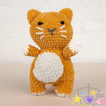 a crocheted cat sitting next to a ball of yarn