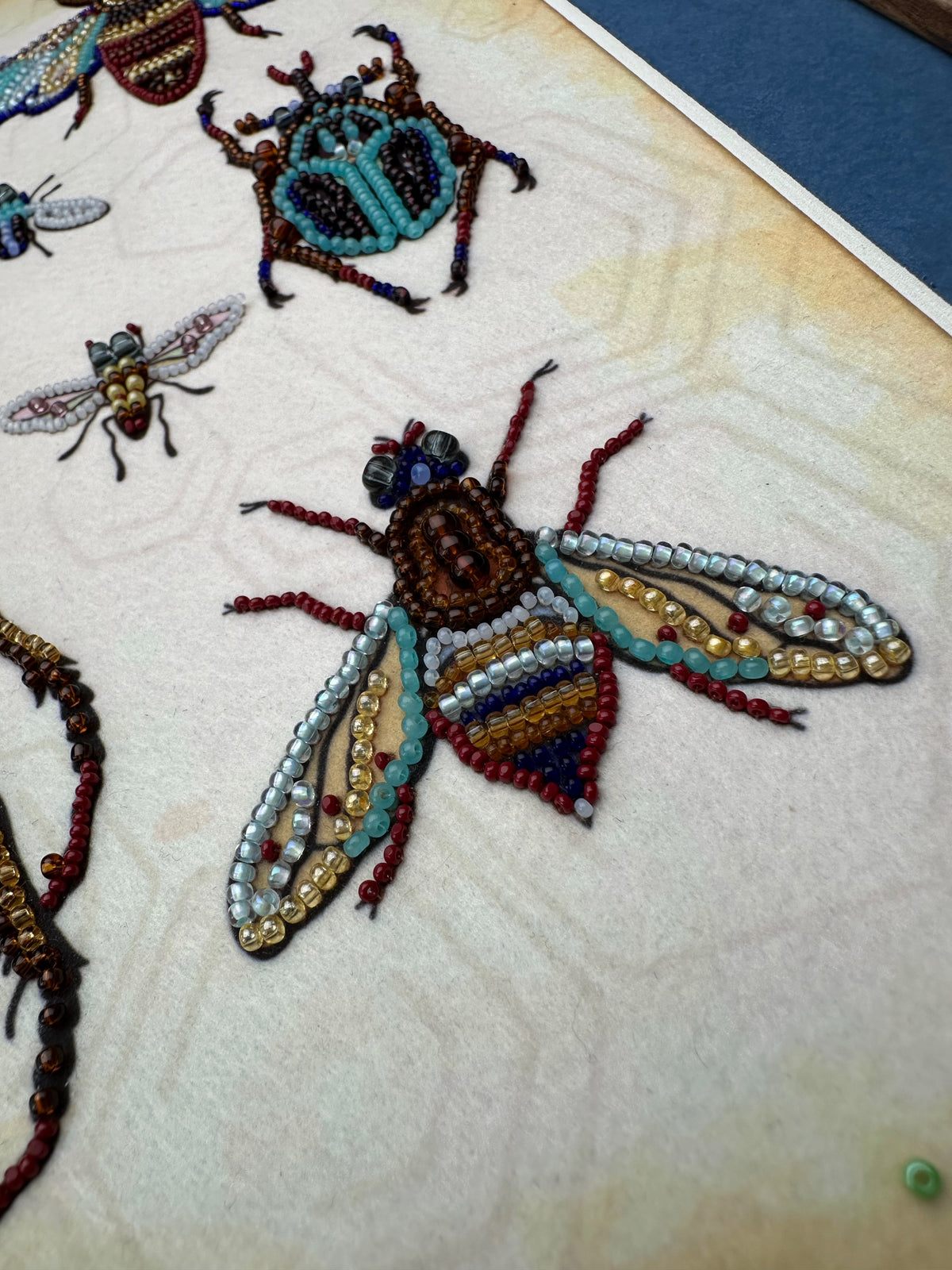 a close-up view of a detailed embroidered or beaded insect, showcasing the intricate craftsmanship and artistry involved in creating such a piece.
