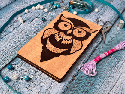 a wooden notebook with an owl on it