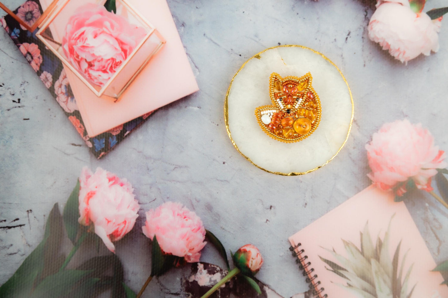 a plate with a gold fox brooch sitting on top of a table