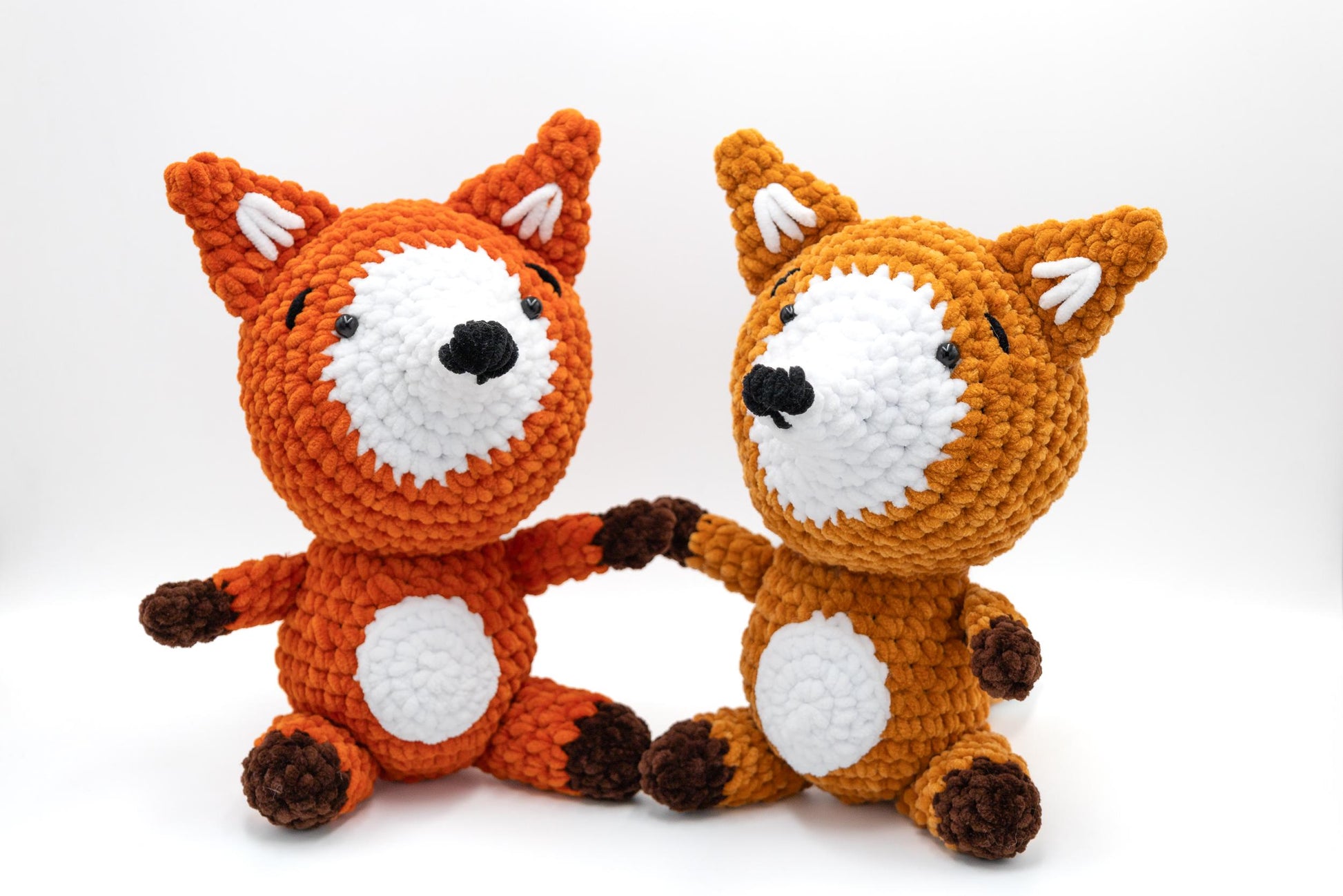 two crocheted stuffed animals sitting next to each other
