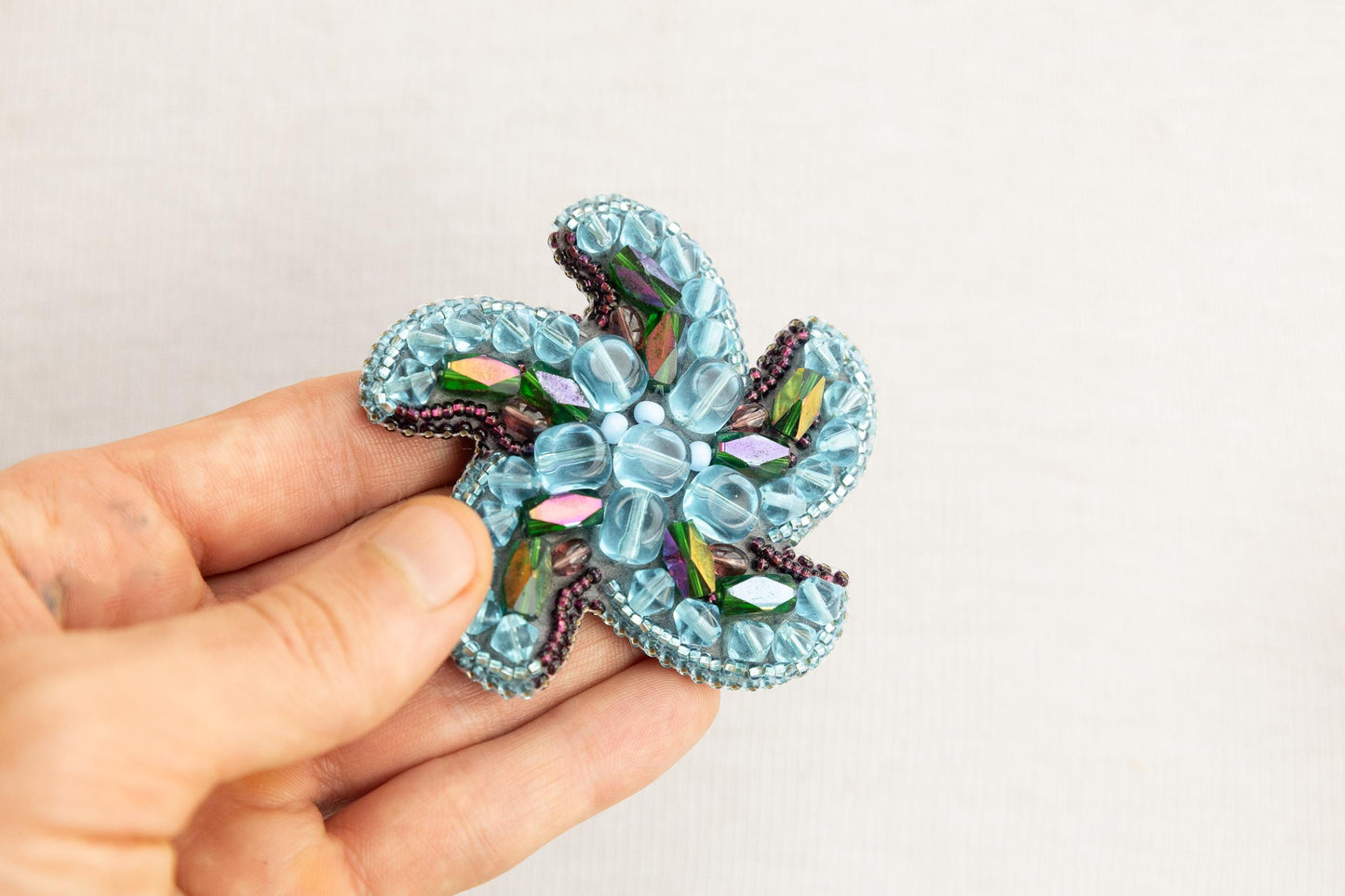 a person is holding a brooch in their hand