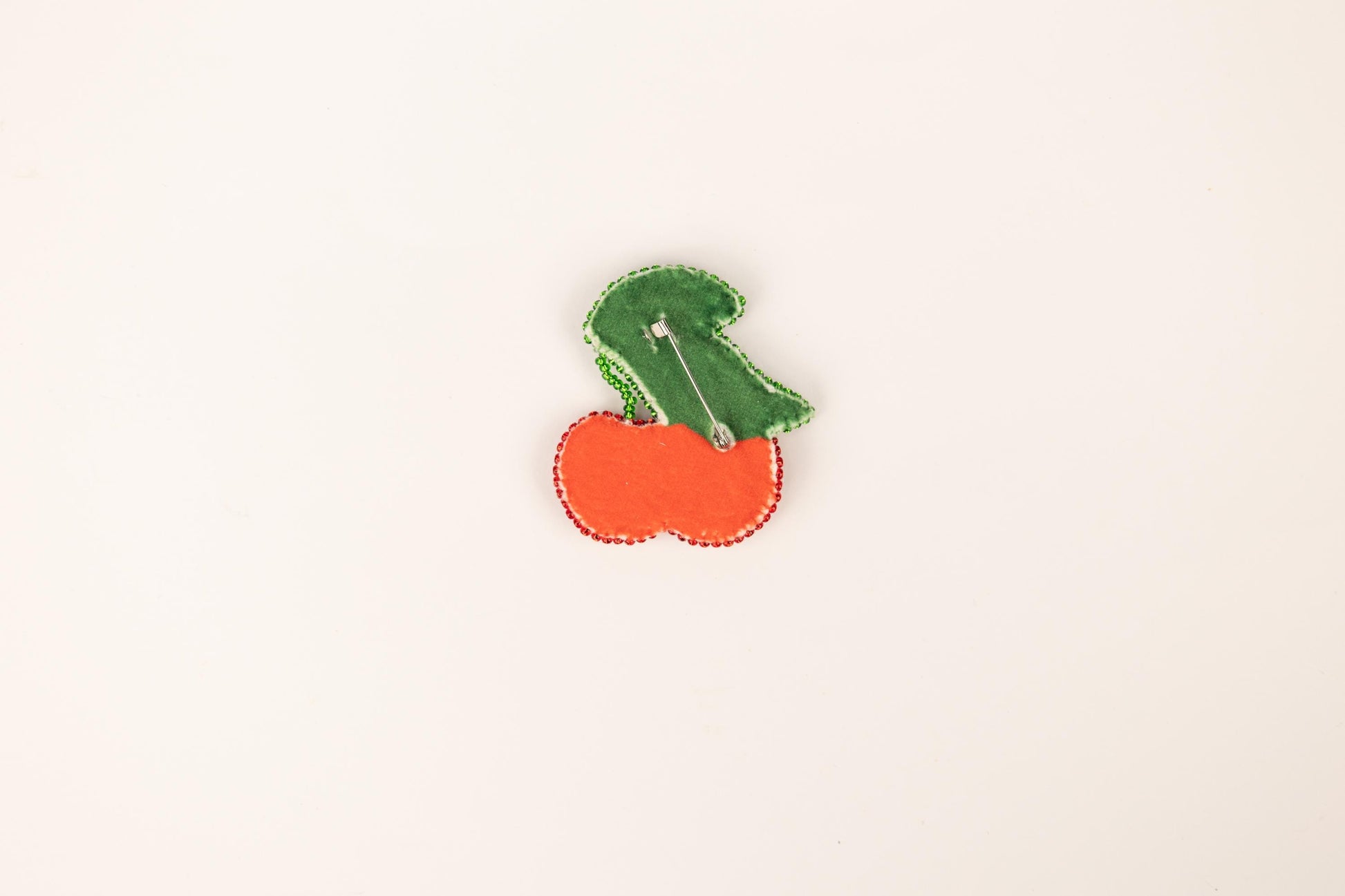 a pin with a carrot and a leaf on it