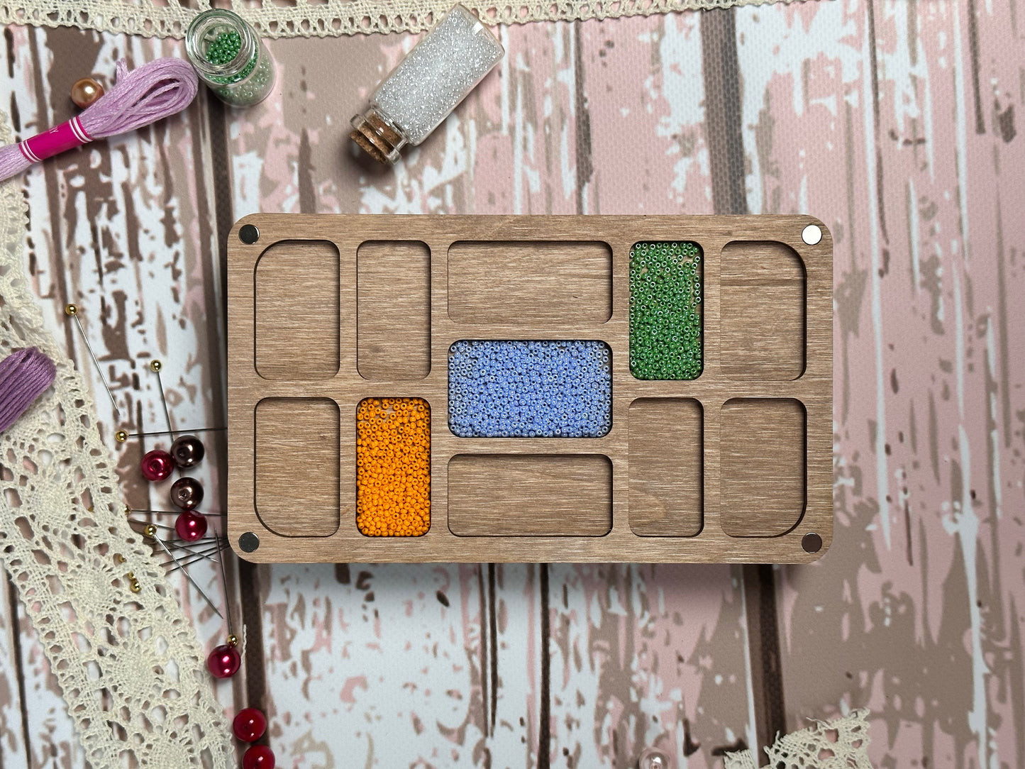 a wooden tray with different colored beads on it
