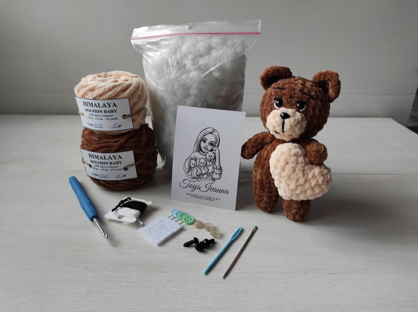 a brown teddy bear sitting next to some yarn