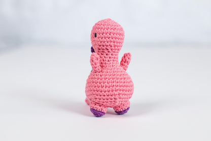 a pink crocheted toy sitting on top of a white table