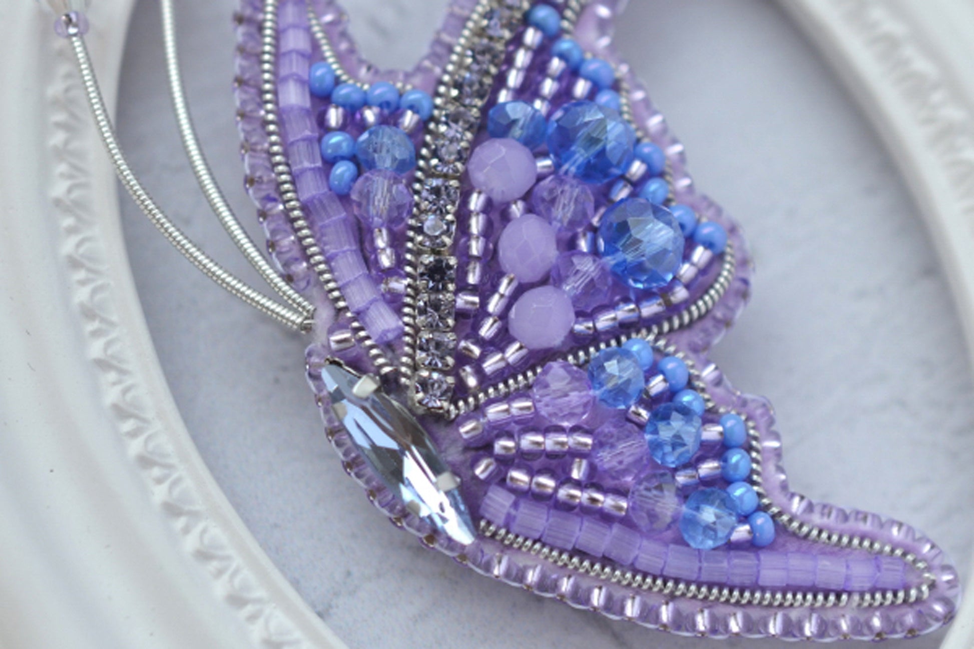 a close up of a purple beaded butterfly