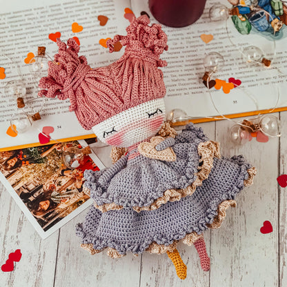 a crocheted doll sitting on top of a book