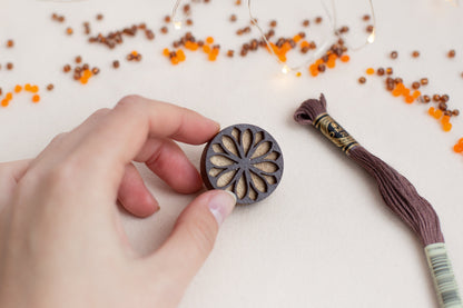 a person is holding a piece of wood with a tassel