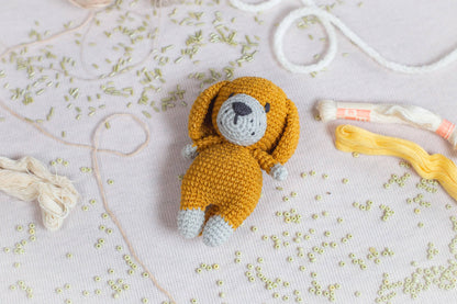 a crocheted teddy bear laying on a table