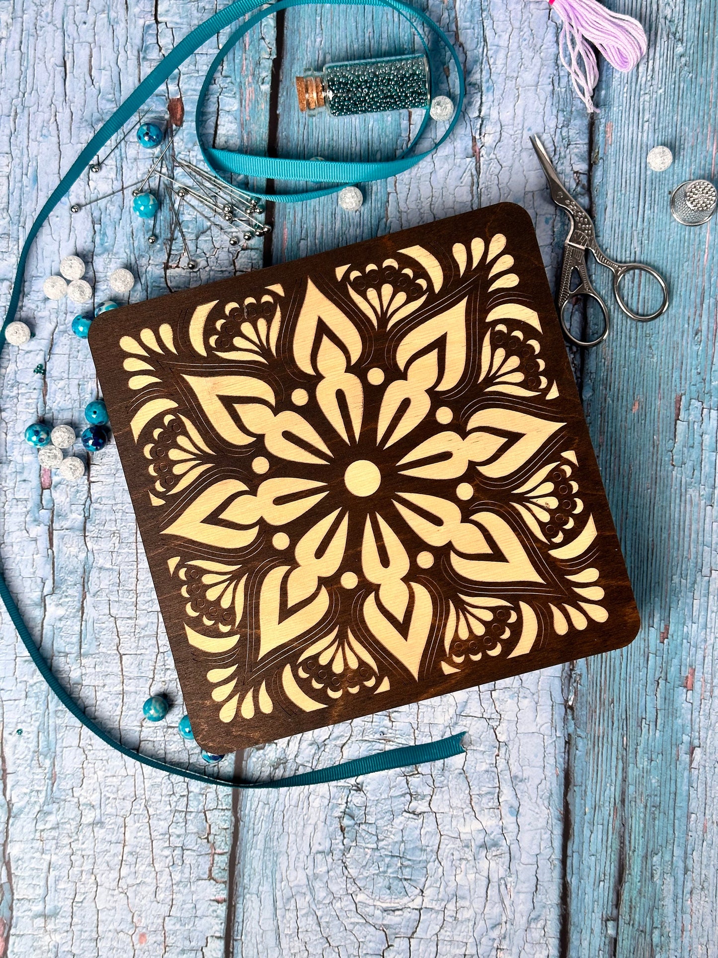 a wooden notebook with a flower design on it
