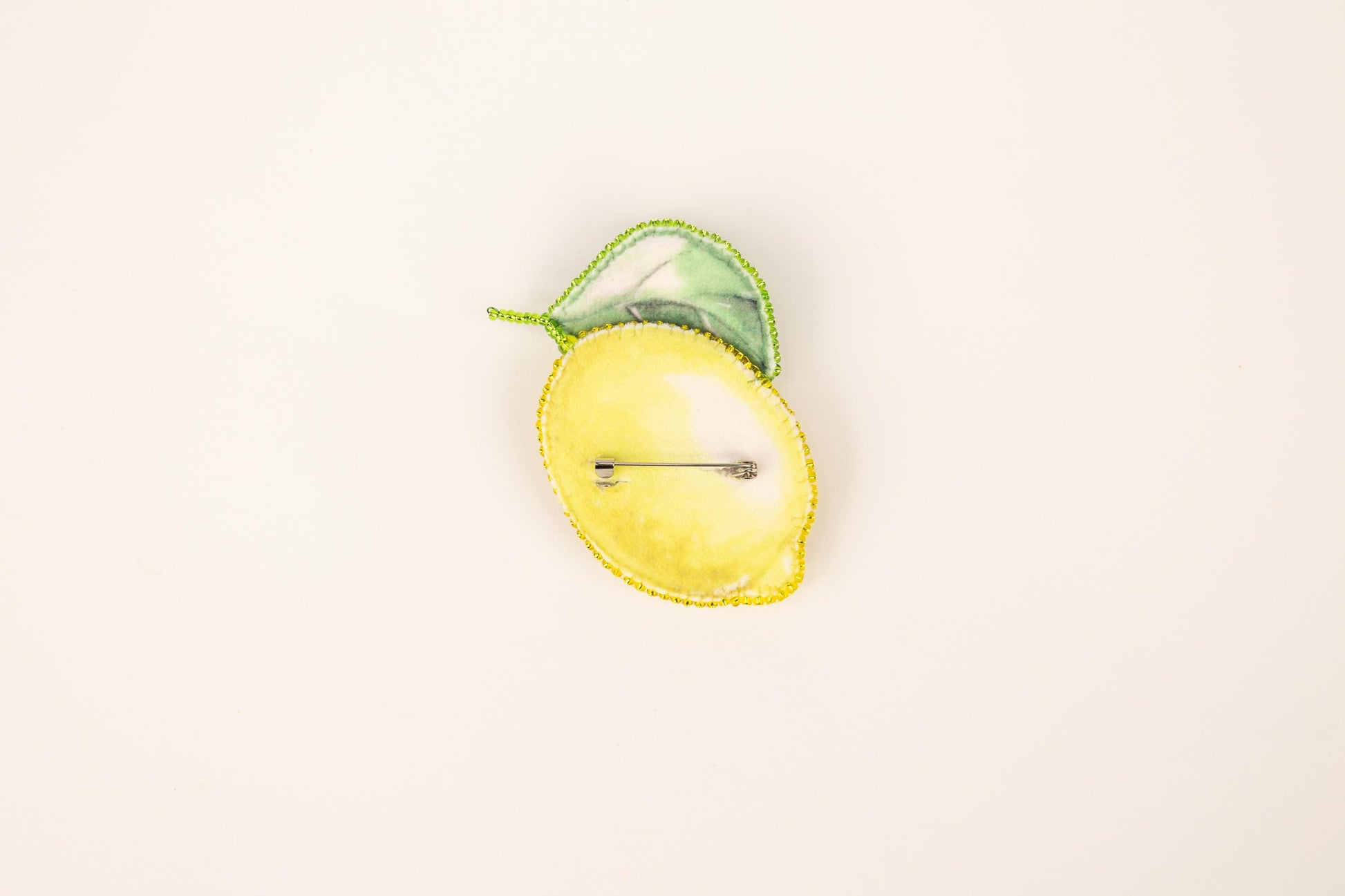 a yellow apple with a green leaf on top of it