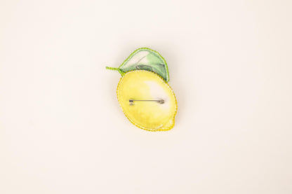 a yellow apple with a green leaf on top of it