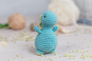 a small crocheted blue toy sitting on top of a table