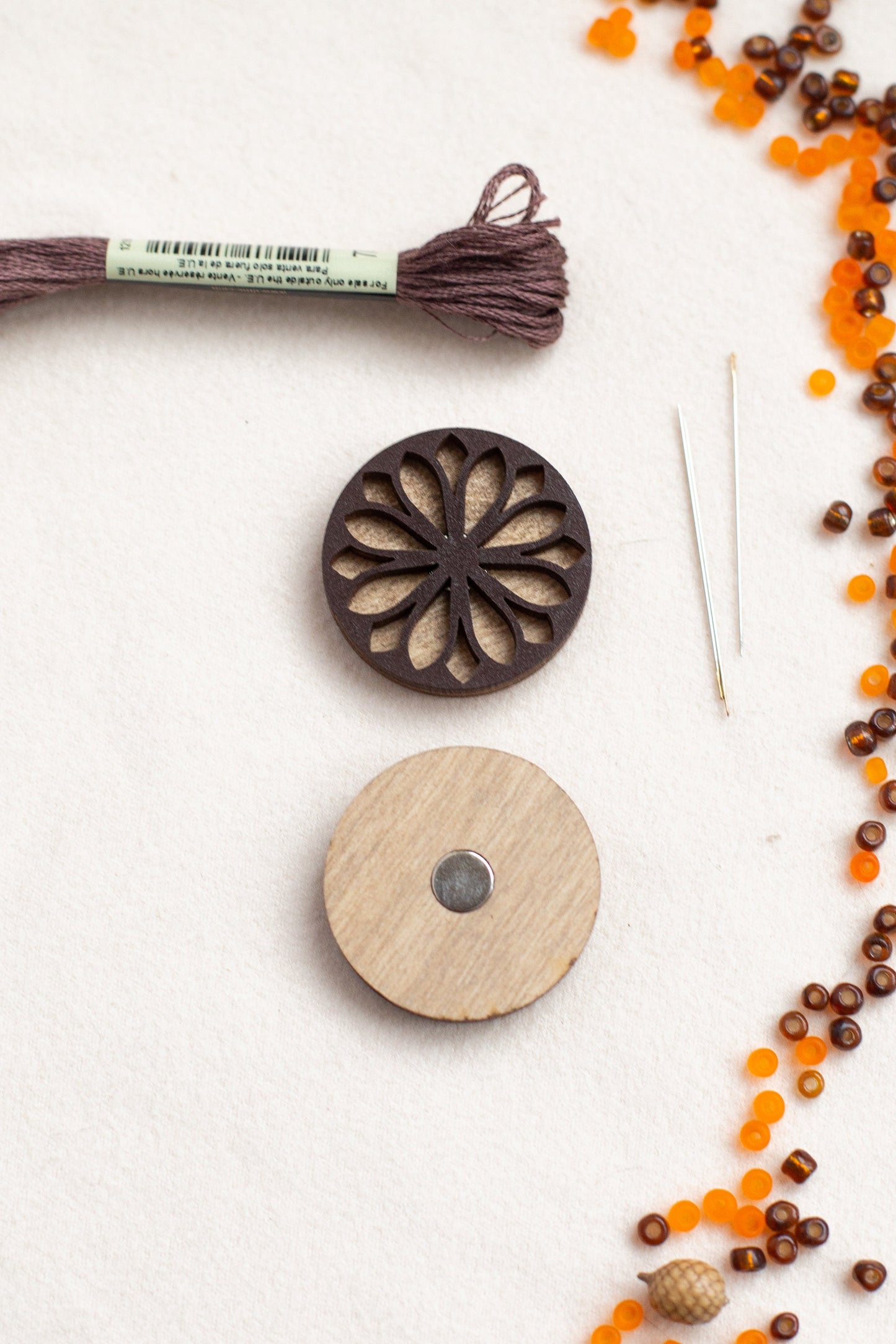 a string of beads, a button, and a piece of wood on a table