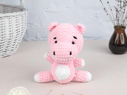 a pink crocheted stuffed animal sitting on a table
