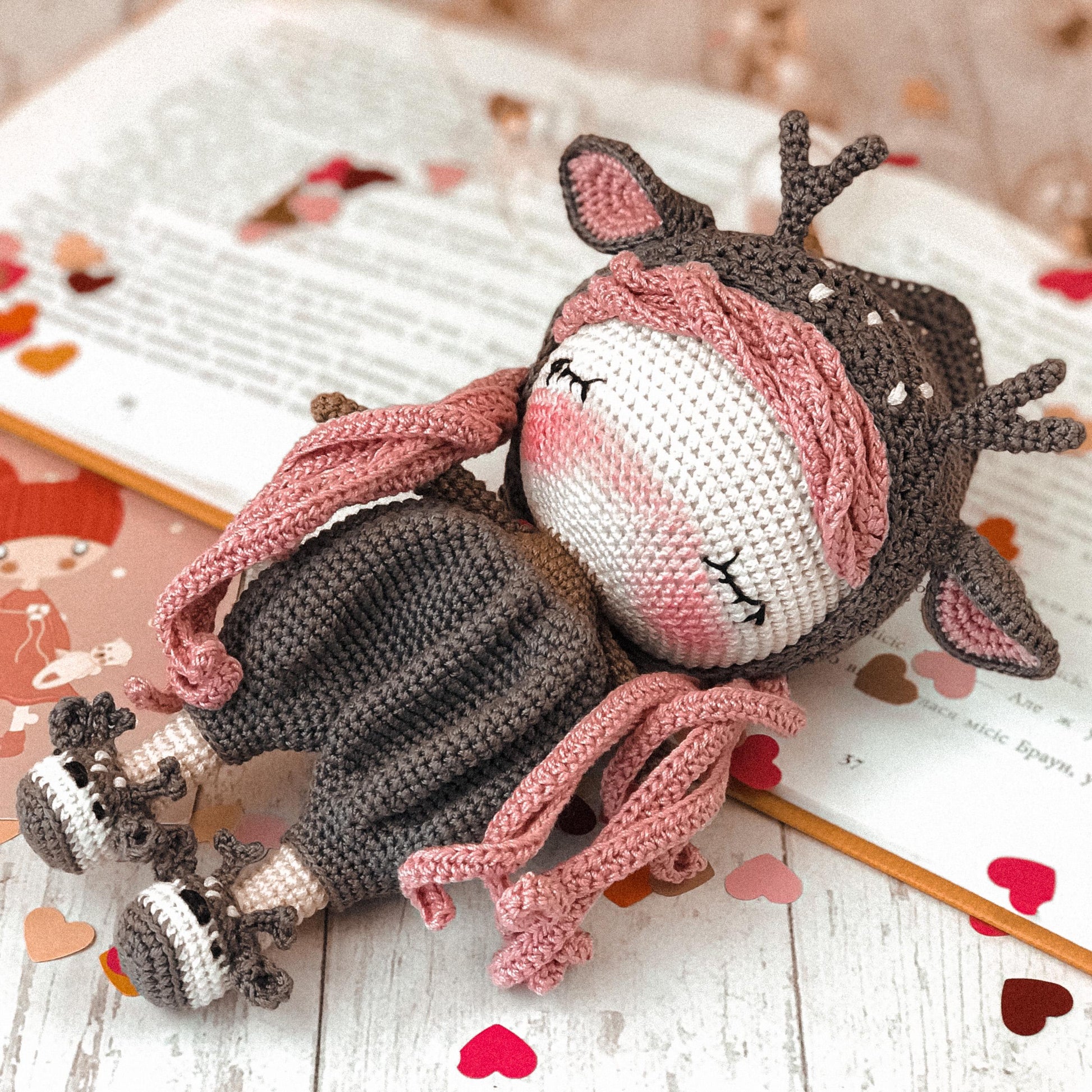 a knitted doll laying on top of an open book