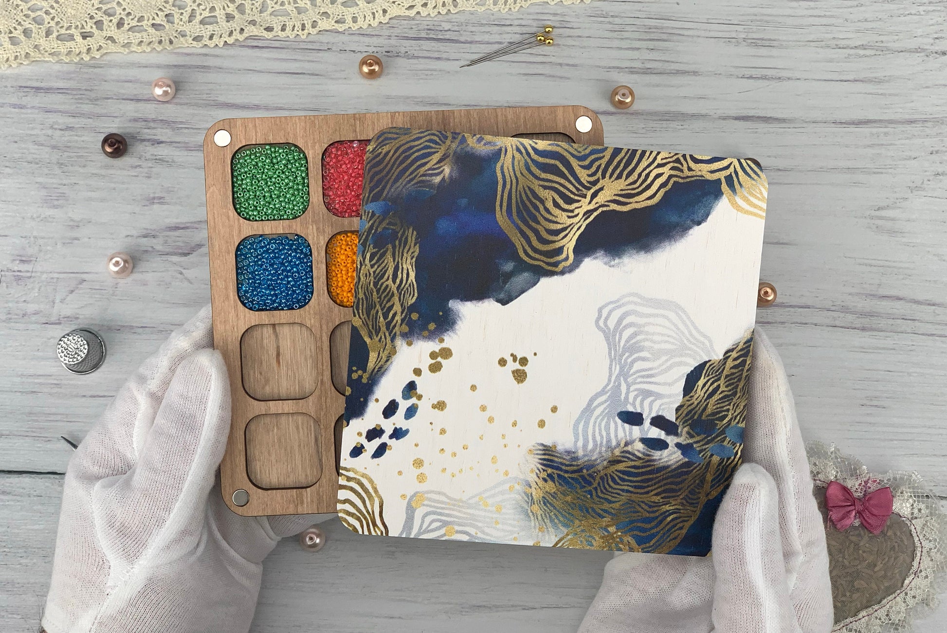 a person&#39;s hands holding a palette of paint