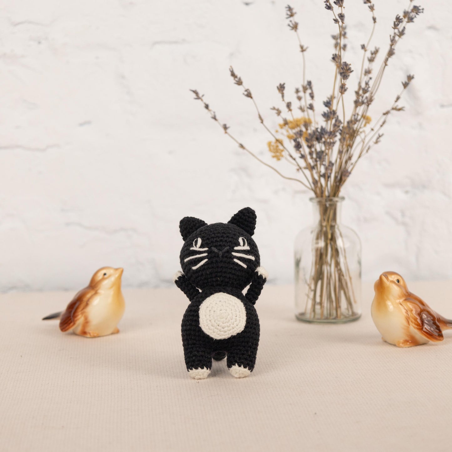 a small crocheted cat and two small birds