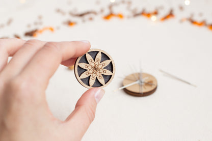 a person is holding a pin with a flower on it