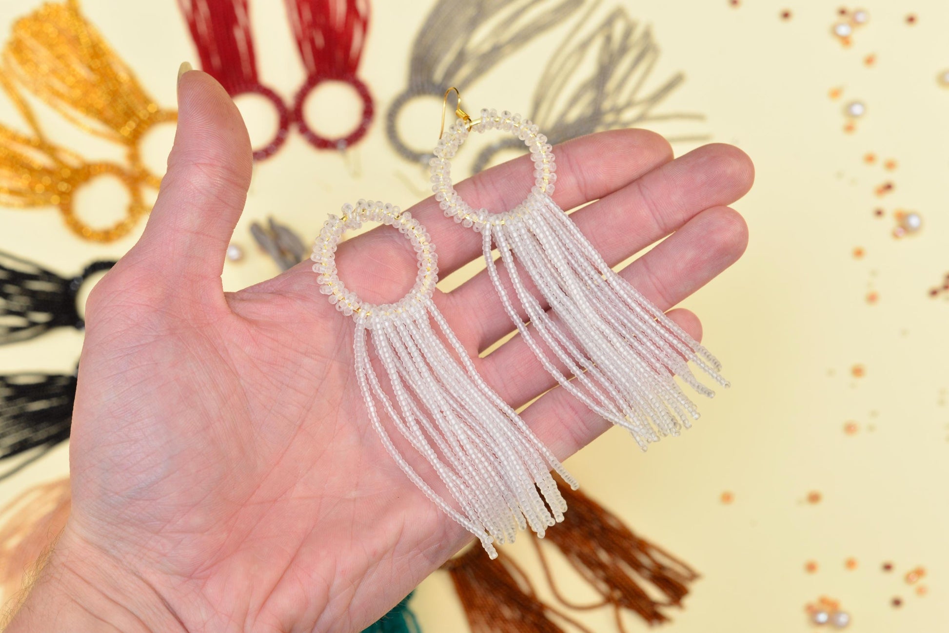 a hand is holding a pair of earrings