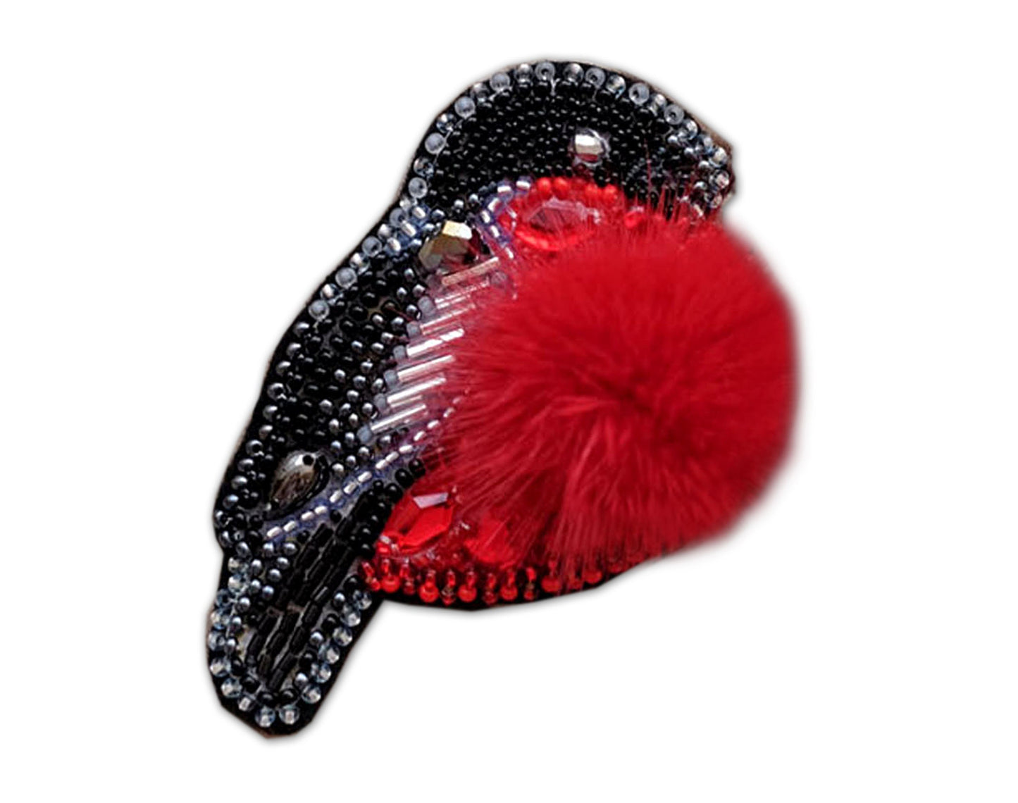 a red pom pom sitting on top of a black comb