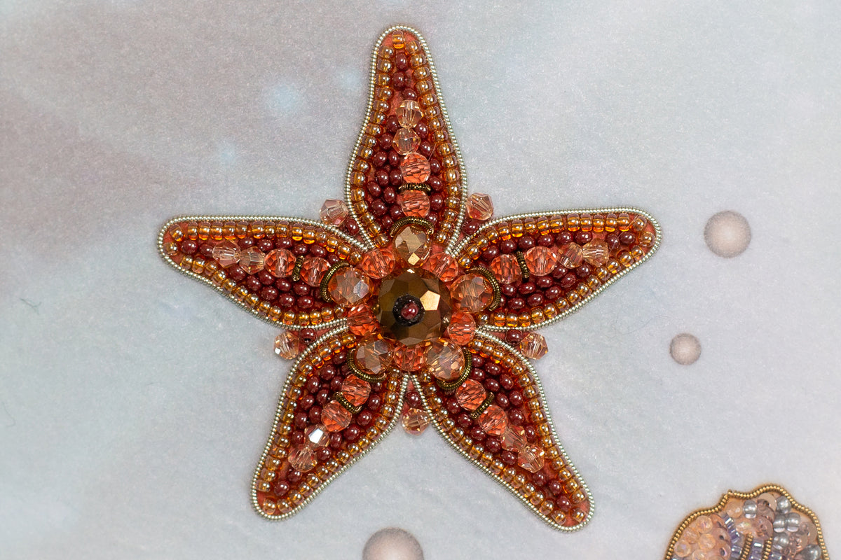 a starfish adorned with various colorful beads and gemstones, creating a visually striking and intricate piece of jewelry.
