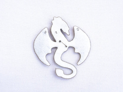 a white brooch with a fish design on it